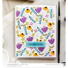 a close up of a card with flowers on it and a cup of coffee next to it