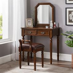 a dressing table with a mirror and stool next to a potted plant on the floor