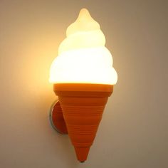 an orange ice cream cone is on the wall next to a light fixture that looks like it has been turned on