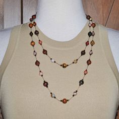 "This is a very pretty hand knotted necklace that has dark brown bead cord with 8mm - 10mm beads in various colors (described below) sandwiched by tiny purple Swarovski bicone crystals with hand knots on each side and 1/2\" space between each set of beads. The crystals lend a shimmery effect on this piece and the brown, tan, cream & rust colors are really beautiful. This is an extra long necklace that can be used as a double strand necklace as shown in the photos above. 53 Inches Long Consists o Brown Double Strand Beaded Necklace For Gift, Artisan Brown Beaded Necklaces With 8mm Beads, Bohemian Brown Beaded Necklaces With 8mm Beads, Bohemian Brown Beaded Necklace With 8mm Beads, Brown Hand-strung Beaded Necklace For Gift, Brown Hand-strung Beaded Necklace Gift, Hand-strung Brown Necklaces For Jewelry Making, Earthy Hand-strung Brown Beaded Necklaces, Earthy Brown Hand-strung Beaded Necklaces