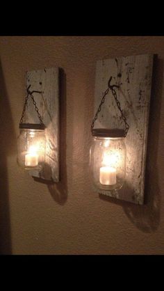 two mason jar lights are hanging on the wall