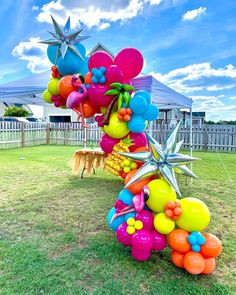 a bunch of balloons that are in the grass