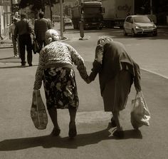 an old couple walking down the street holding hands