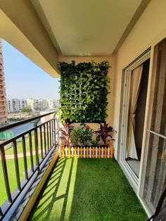 an apartment balcony with grass and plants on the balconies, overlooking a cityscape