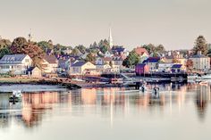 boats are parked on the water in front of houses