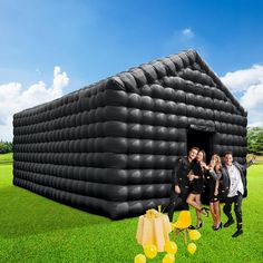 group of people standing in front of an inflatable house with balloons on the lawn