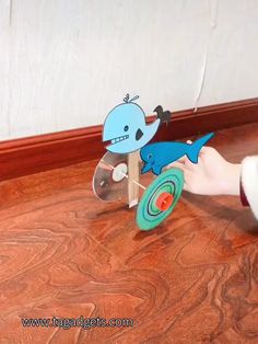 a person is playing with a toy shark on the floor next to a door handle