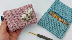 two crocheted wallets with flowers on them, one is pink and the other is blue