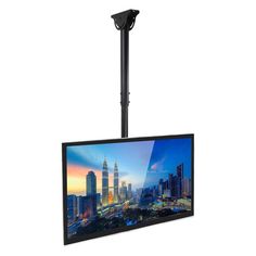 a flat screen tv mounted to the side of a pole with a cityscape in the background