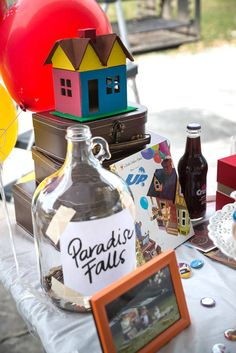 a table topped with lots of bottles and balloons