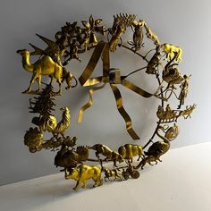 a metal clock with gold colored animals on it's face and numbers in the middle