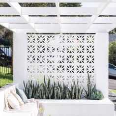 an outdoor living area with white walls and plants