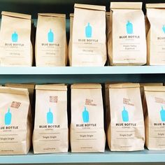 several bags of blue bottle coffee sit on shelves