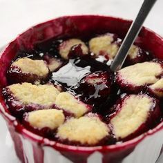 a dessert in a bowl on a plate with a spoon