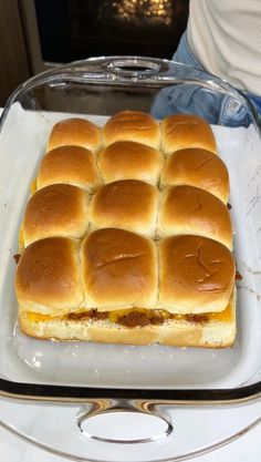 a square sandwich sitting on top of a white plate next to a glass container filled with cheese