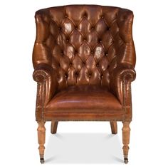 a brown leather chair with wooden legs and nail polishing on the armrests