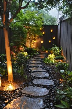 a stone path in the middle of a garden with lights on each side and trees around it