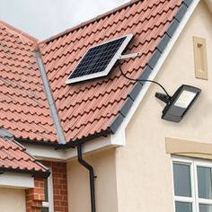 a house with a solar panel on the roof and a street light attached to it