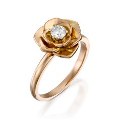 a gold ring with a flower on the side and a diamond in the center,