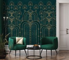 two green chairs sitting next to each other in front of a wall with art deco design