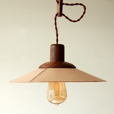 a light hanging from a ceiling with a brown cord attached to the end of it