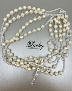 Ivory Pearls set apart with small crystal beads attached to a classic crucifix (choice of Gold or Silver Cross) adorn this lasso exclusively designed by Lucky Collections™. Available on www.ProBridalUSA.com *High-quality Ivory Pearls and Brilliant Crystals, Silver-Gold Plated Cross *Handmade with Love *The Lasso has two loops. Each loop fits one person. * Safekeep the memorable moment of Lasso Unity Ceremony in a lasso box also designed by Lucky Collections™ * Ideal for Spanish Catholic Wedding, Elegant Pearl Rosary With 8mm Beads, Elegant Pearl Rosary For First Communion, Silver Pearl Bridal Accessories For Bride, Adjustable Pearl Bridal Accessories For Wedding, Pearl White Pearl Bridal Accessories, Elegant Pearl White Rosary With Round Beads, Elegant Silver Rosary For First Communion, Elegant White Rosary For First Communion, Silver Pearl Bridal Accessories