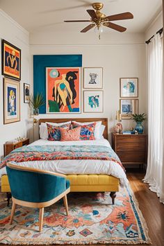 a bedroom with a bed, chair and paintings on the wall