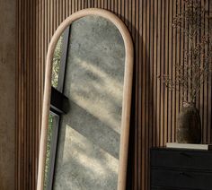 a large mirror sitting on top of a wooden wall