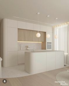 a modern kitchen with white cabinets and wood flooring is shown in this image, there are three lights hanging from the ceiling