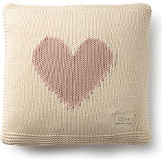 a knitted pillow with a pink heart on it