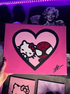 a person holding up a pink heart with hello kitty on it and other pictures in the background