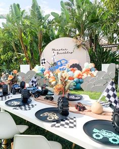 a table set up with racing themed plates and decorations for a race car birthday party