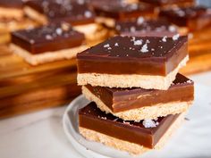 three pieces of chocolate and marshmallows on a white plate next to a cutting board