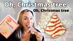 a woman is eating a christmas tree cookie