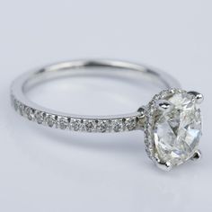 a white gold engagement ring with an oval cut diamond and pave set diamonds around the band