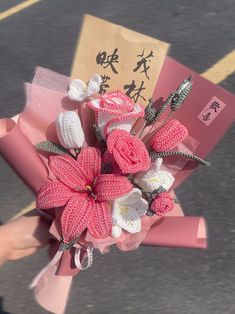 a bouquet of flowers is being held by someone's hand on the street in china