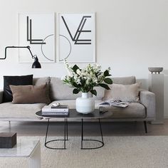 a living room with a couch, coffee table and pictures on the wall above it