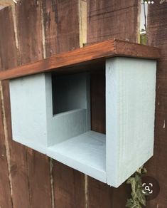 a bird house built into the side of a wooden fence