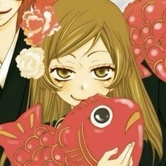 an anime character holding a fish with flowers in her hair