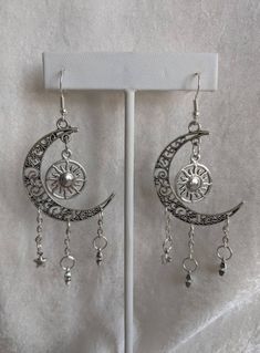 A gorgeous pair of earrings featuring earth's surrounding celestial bodies: the moon, the sun, and the stars. Choose between silver as pictured or bronze! Silver Star-shaped Alloy Jewelry, Celestial Dangle Jewelry With Moon Charm, Celestial Sun And Moon Dangle Jewelry, Celestial Moon Phase Moon Earrings, Celestial Star-shaped Festival Jewelry, Celestial Star Jewelry For Festival, Celestial Style Silver Metal Jewelry, Celestial Festival Star Jewelry, Mystical Silver Star Jewelry