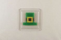 a close up of a small plastic object on a white surface with bead designs