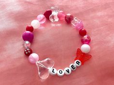 "❦ express your love wherever you go with these adorable \"lover\" valentine's day themed bracelets! ❦ size: 17-18cm / 7-8inches. the string is a stretchy material made to comfortably fit a wide variety of wrist sizes! ❦ created using a wide variety of round red, white, and pink colored beads. includes the words \"lover\" using round letter beads ❦ DISCLAIMER: all bracelets will be slightly unique to one another since i incorporate different beads in each one. the bracelet you receive may not be Themed Bracelets, Lover Bracelet, Valentines Galentines, Jewelry Friendship, Lovers Bracelet, Galentines Day, Valentine Ideas, Pink Valentines, Letter Beads