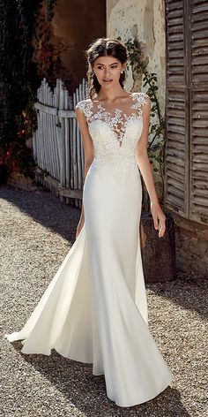 a woman in a wedding dress standing outside