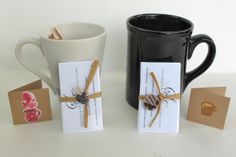 two coffee mugs with tags attached to them