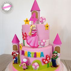 there is a pink cake with mario and princesses on it