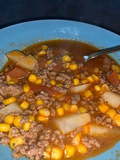 a blue plate topped with corn and meat soup