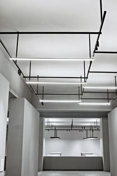 an empty room with white walls and lights on the ceiling is shown in black and white