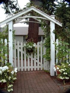 a white picket fence with flowers around it