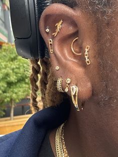 a close up of a person with ear piercings on their ears and in front of a building