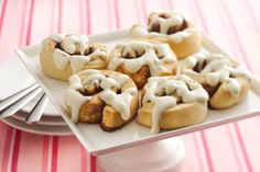 a white plate topped with pastries covered in icing